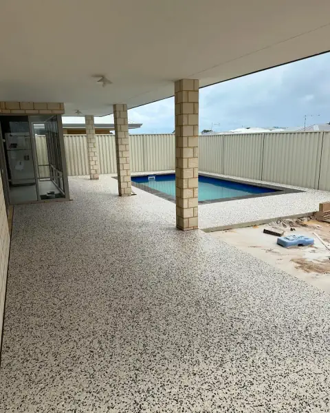 Exposed aggregate alfresco floor under the roof, running out to the pool surround beyond