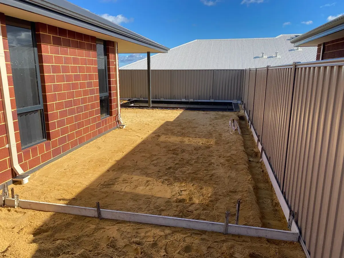 Side yard prepped and boxed for a pool surround, pool shell in and the sand levelled