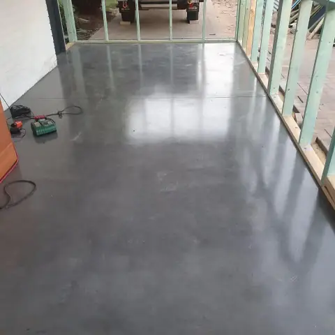 Burnished grey concrete floor inside a house that is still at frame stage